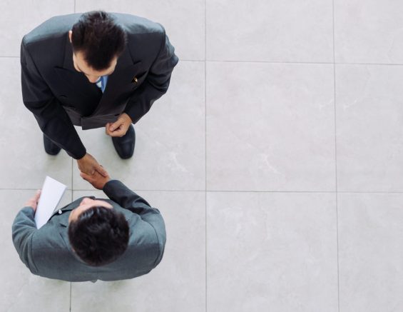 Two men shaking hands from above